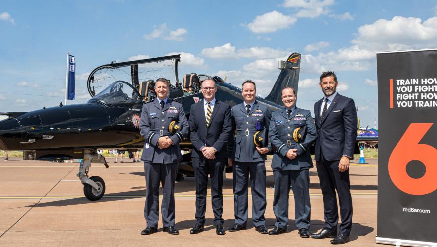 Representatives of BAE Systems and Red 6 pose with RAF officers in front of a Hawk T.Mk 2 during the Royal International Air Tattoo event held at RAF Fairford on July 19-21, 2024.