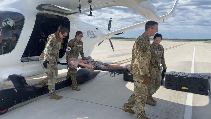 Four members of the Air Mobility Command are pictured with the Alia prototype during a medevac exercise 